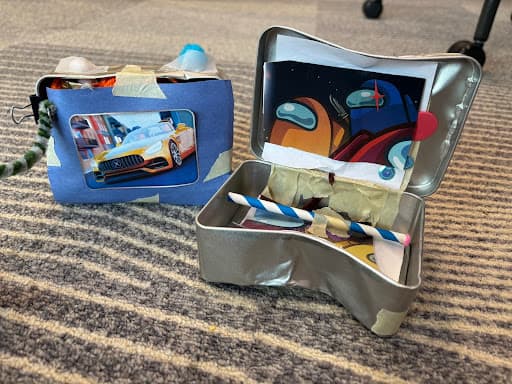 A handmade 'Portable Remixer' prototype built from decorated tins, tape, and paper by children